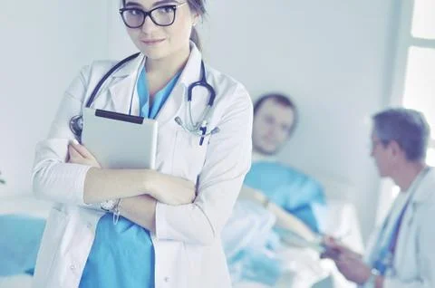 Female doctor using tablet computer in hospital lobby Stock Photos