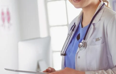 Female doctor using tablet computer in hospital lobby Stock Photos
