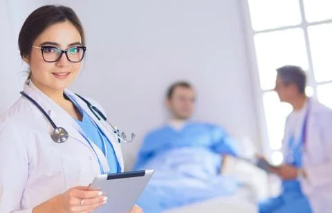 Female doctor using tablet computer in hospital lobby Stock Photos