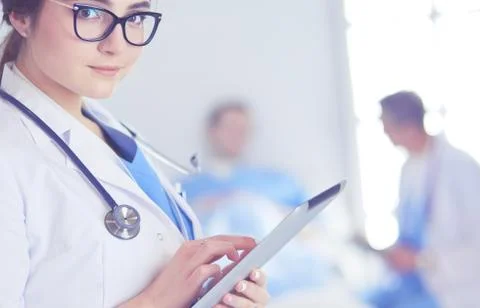Female doctor using tablet computer in hospital lobby Stock Photos