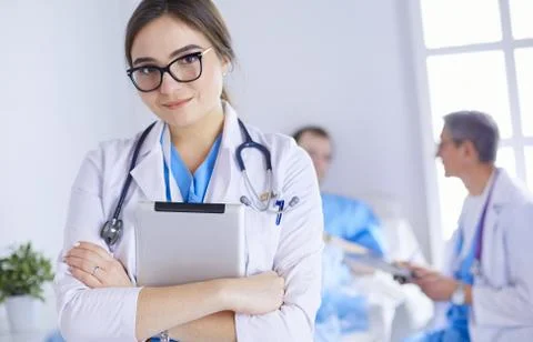 Female doctor using tablet computer in hospital lobby Stock Photos