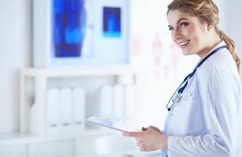 Female doctor using tablet computer in hospital lobby Stock Photos
