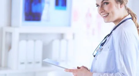 Female doctor using tablet computer in hospital lobby Stock Photos