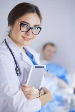 Female doctor using tablet computer in hospital lobby Stock Photos