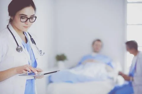Female doctor using tablet computer in hospital lobby Stock Photos