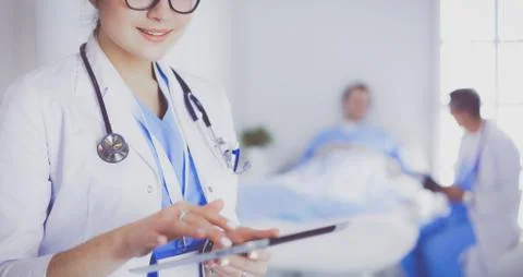 Female doctor using tablet computer in hospital lobby Stock Photos