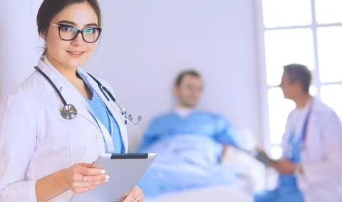 Female doctor using tablet computer in hospital lobby Stock Photos