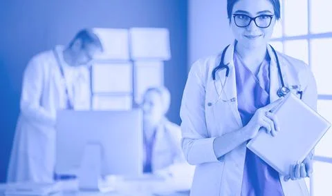 Female doctor using tablet computer in hospital lobby Stock Photos