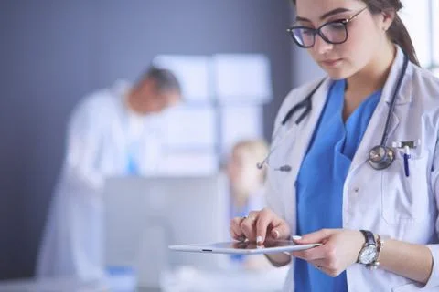 Female doctor using tablet computer in hospital lobby Stock Photos