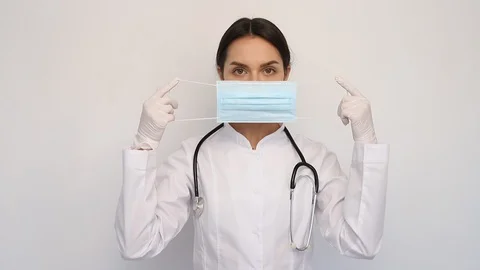 Female doctor in white medical coat, wearing a protective mask Stock Footage