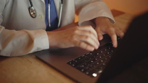 Female doctor working at a computer. The scene starts at the hands. Monitor t Stock Footage 148349136