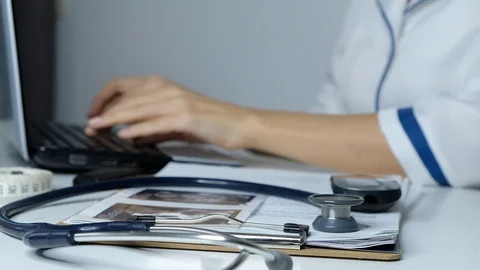 Female doctor working on a computer, typing on laptop, filling data close up Stock Footage 121135844