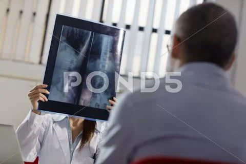 Female doctor working in hospital with patient and x-rays Stock Photos