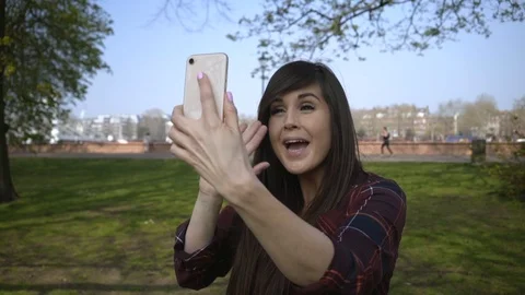 Female doing a facetime call in a park Stock Footage 105489698