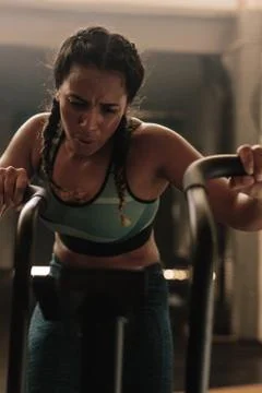 Female doing intense workout on exercise bike Stock Photos