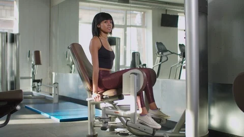 Female doing weight exercise at inner thigh machine Stock Footage 122030884