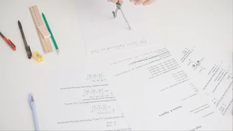 Female draws correct answer in geometry exam test paper with divider. Student Foto stock