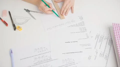 Female draws correct answer in geometry exam test paper with pencil and ruler Stock Photos