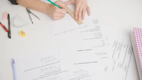 Female draws correct answer in geometry exam test paper with pencil and ruler Stock Photos