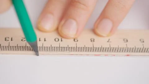Female draws correct answer in geometry exam test paper with pencil and ruler Stock Photos