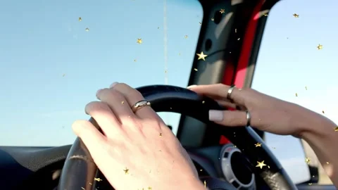 Female driver adjusting steering for auto lane drift fix, gold stars drifting Stock Footage 333286415