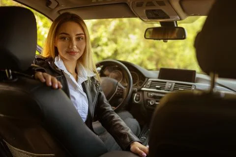Female driver checking behind before reversing car safely Stock Photos