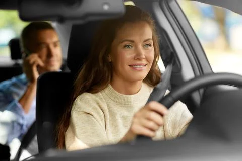 Female driver driving car with male passenger Stock Photos