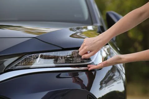 Female driver hands checking headlight of her new car. Purchase of vehicle Stock Photos