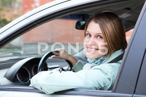 Female driver looking back from car window Stock Photos