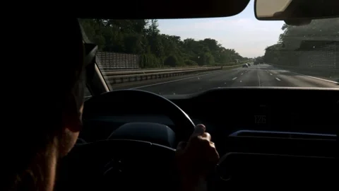 Female driver navigating a highway in a modern vehicle, hands on steering wheel, Stock Footage 338289419