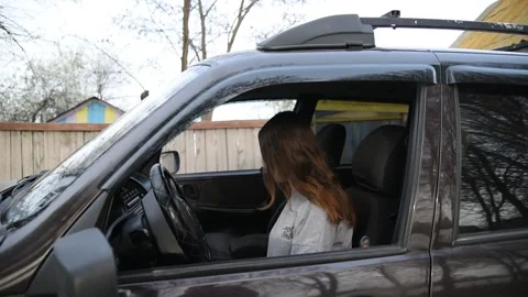 A female driver puts on a face mask and gloves in the car Stock Footage 131143364