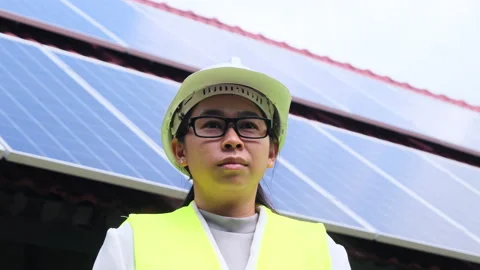 Female electrical engineer in a helmet standing near solar panels. Vídeo Stock 172394854