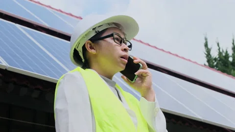 Female electrical engineer talks on smartphone near solar panels. Stock Footage 172393847