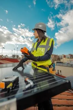 Female electrician engineer using Multimeter on domestic urban Solar Panels Stock Photos
