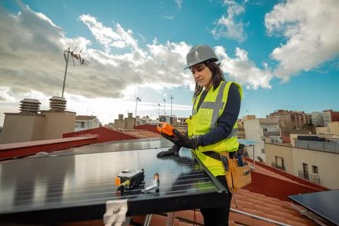 Female electrician engineer using Multimeter on domestic urban Solar Panels Stock Photos