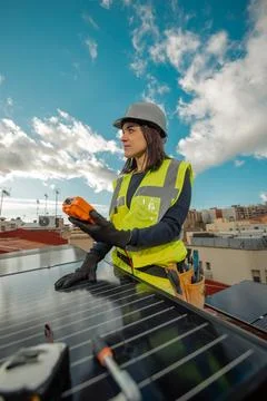 Female electrician engineer using Multimeter on domestic urban Solar Panels Stock Photos