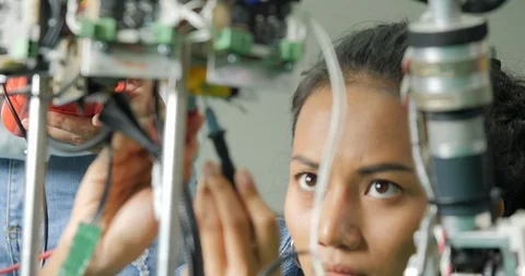 Female electronics engineer building, testing, fixing robotics in laboratory. Stock Footage 94653301