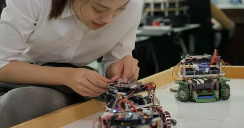 Female electronics engineer works with robot, building, fixing robotics in Video stock 94657052