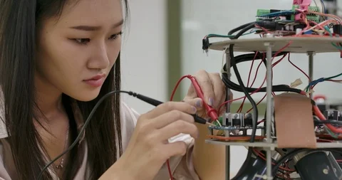 Female electronics engineer works with robot, building, fixing robotics in works Stock Footage 111826440