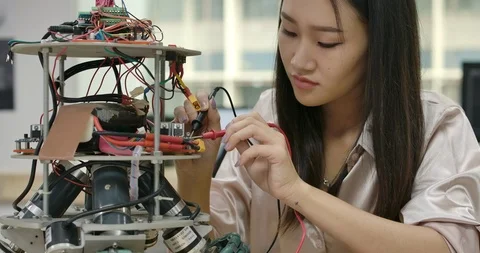 Female electronics engineer works with robot, building, fixing robotics in works Vídeos de archivo 111827946