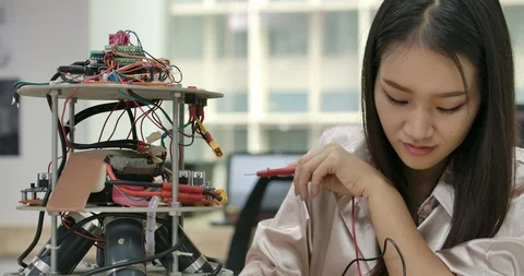 Female electronics engineer works with robot, building, fixing robotics in works Vídeos de archivo 111828115