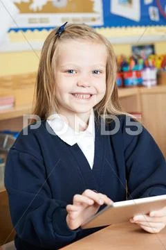 Female Elementary School Pupil Using Digital Tablet In Class Stock Photos