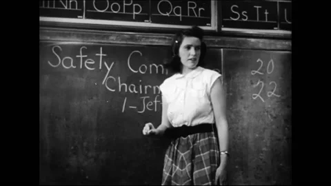 Female Elementary School Teacher In Classroom Writing On Blackboard Stock Footage 157787961