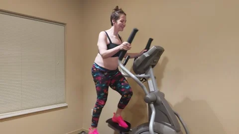 Female on elliptical machine Stockbeeldmateriaal 255449283