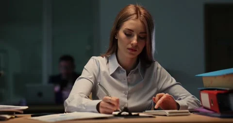 Female employee absorbed in calculation work late in office Stock Footage 281372976