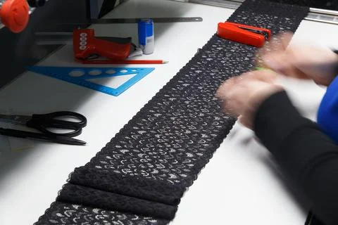 A female employee performs visual quality control of the lace ribbon Фото