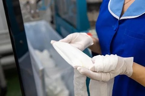 A female employee performs visual quality control of hosiery. Фото