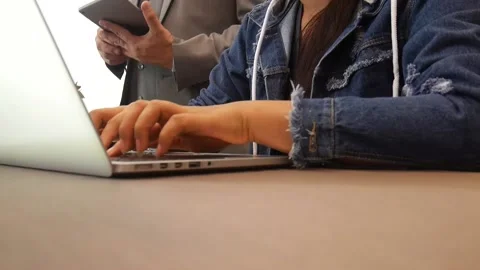 Female employee typing on notebook computer with boss behind her Stock Footage 164516362