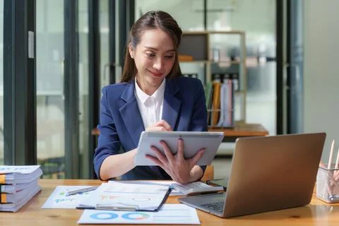 Female employee using laptop at workplace. Businesswoman preparing economic Stock Photos