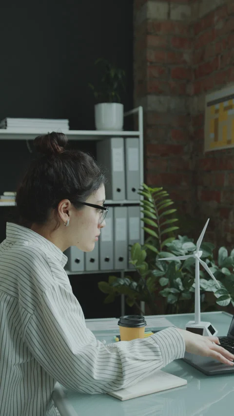 Female Engineer Analyzing Renewable Energy Presentation on Laptop in Office Stock Footage 270530776